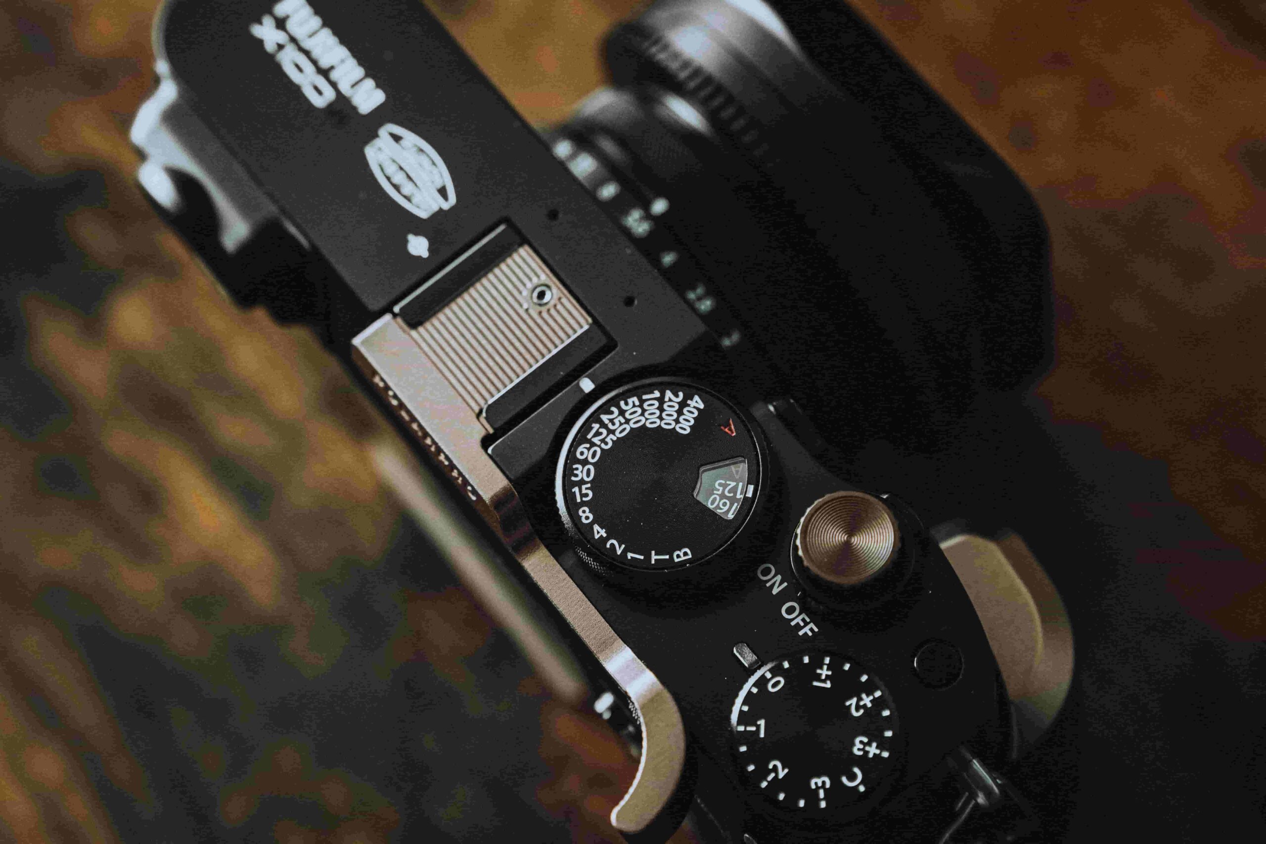 A close up shot of the top of a Fujifilm camera with all its controls and settings.