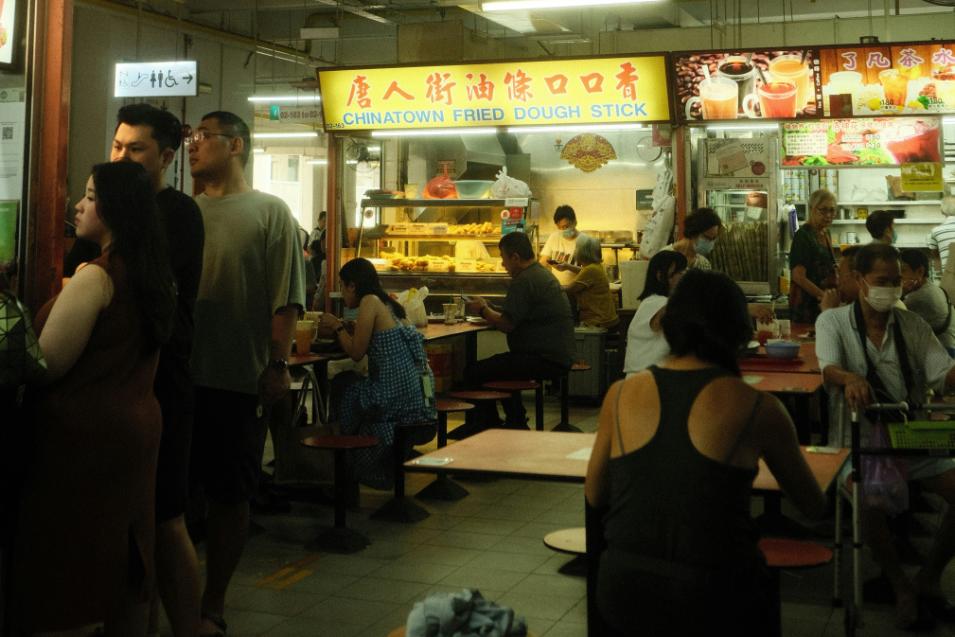 An image of a busy Hawker food center full of locals and food goers coming together to enjoy a meal or two.