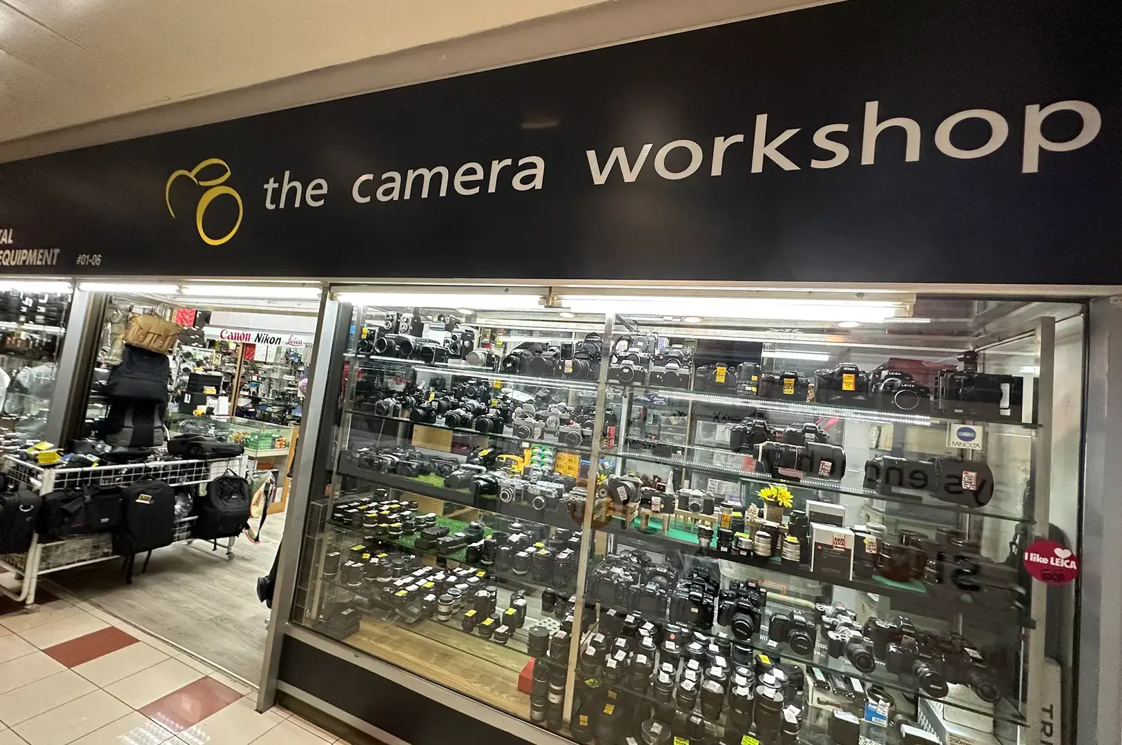The Camera Workshop storefront with a glass display filled with cameras, lenses, accessories, and photography equipment.